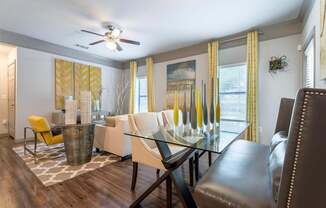 A modern dining room with a glass table and chairs.
