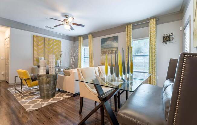 A modern dining room with a glass table and chairs.
