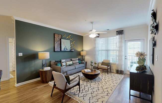 Living room with couch and chair; door to patio or balcony