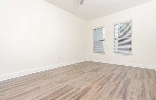 a bedroom with hardwood floors and white walls