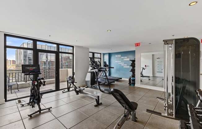 the gym with floor to ceiling windows and exercise equipment