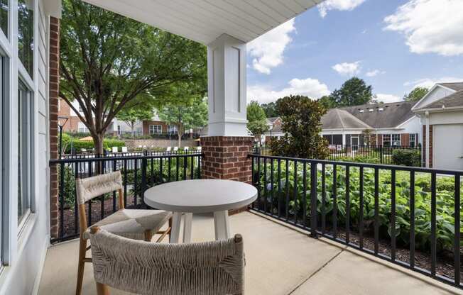 a patio with two chairs and a table on a balcony