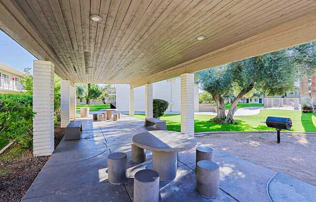 A concrete patio with a wooden roof and a mailbox.