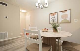 A dining room with a round table and chairs.