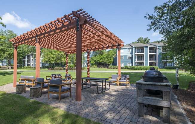 a group of tables and chairs in an outdoor picnic BBQ area at Wynnwood Vinings apartments