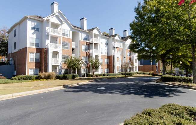 A large apartment complex with a parking lot in front.