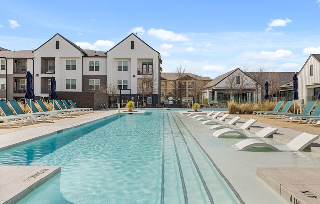 A large swimming pool in front of apartment buildings.