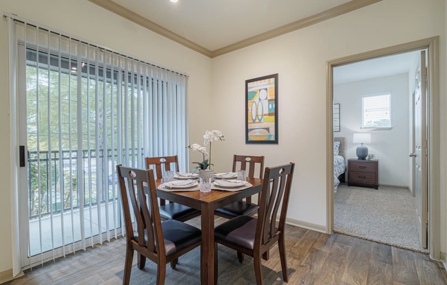 a dining room with a wooden table and chairs and a sliding glass door