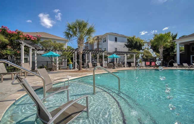 A pool with a chair and a waterfall.