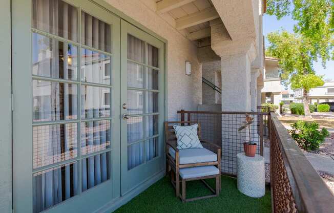 A patio with a chair and a table with a pillow on it.