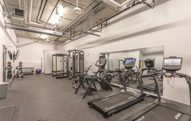 a large fitness room with treadmills and other exercise equipment