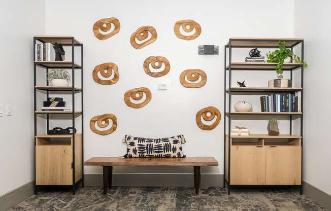 a room with two bookshelves and a bench with a pillow and a plant on it