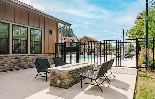 A patio with a table and chairs is in front of a house.