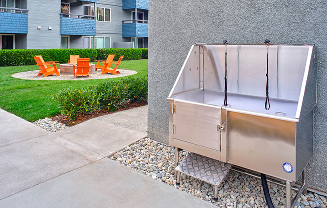 a stainless steel dog wash station sits on the side of a sidewalk in front of an apartment building  at 3030 Lake City, Seattle