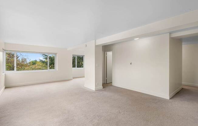 a living room with white walls and a large window