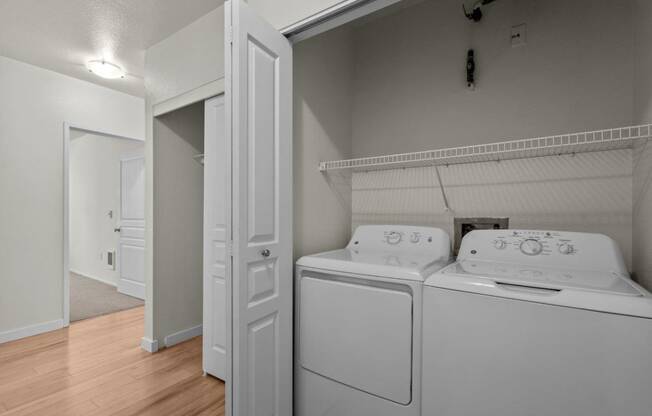 a washer and dryer in a room with a door to a closet