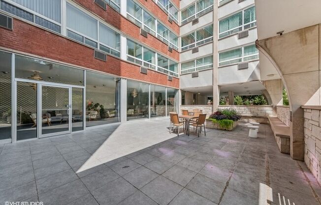 a courtyard with a table and chairs in front of an apartment building