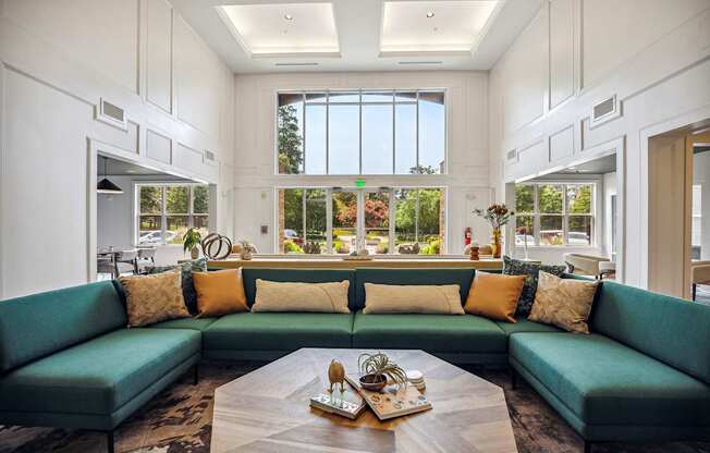 A living room with a green couch and a coffee table in the center.
