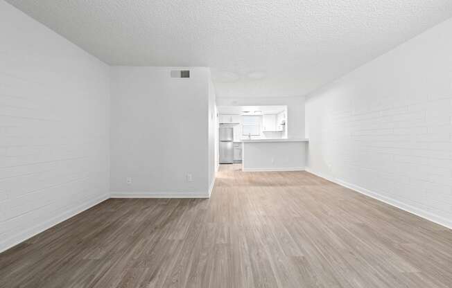 a bedroom with a hardwood floor and white walls