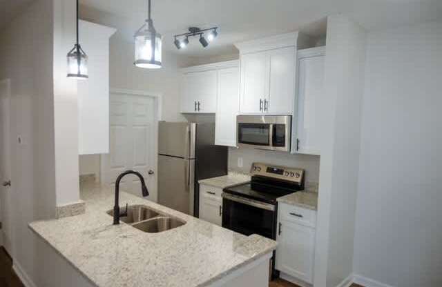 A kitchen with granite countertops and stainless steel appliances.