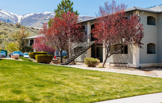 a white building with trees and mountains in the background