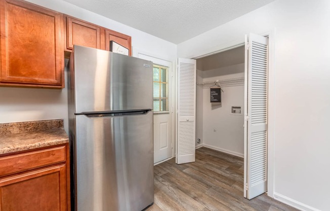 a kitchen with a stainless steel refrigerator and wooden cabinets