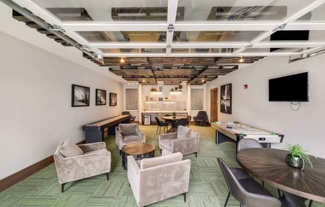 a living room with chairs tables and a pool table