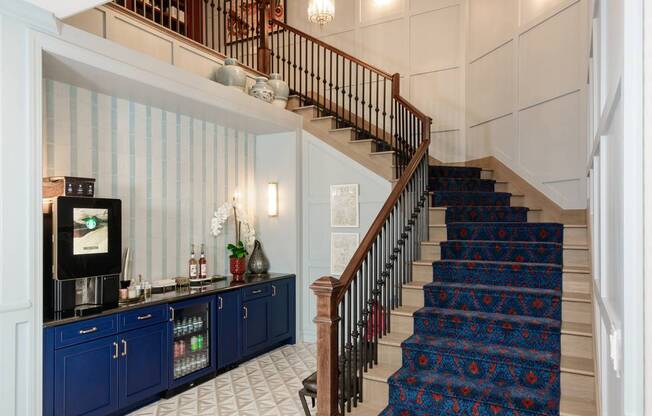 A staircase with a blue carpeted runner and a wooden handrail.