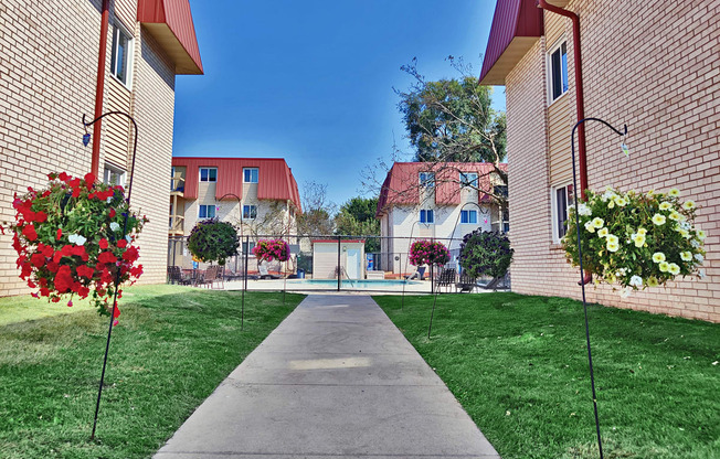 a sidewalk leading to a yard with a pool in the middle