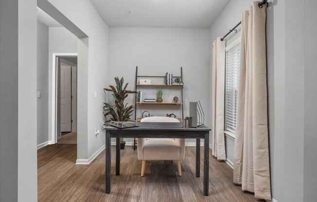 a bedroom with a desk with a chair and a window