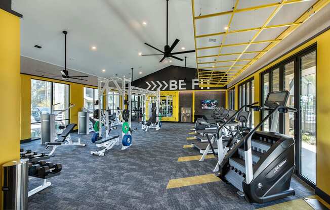 a gym with treadmills and other exercise equipment in the lobby of a building
