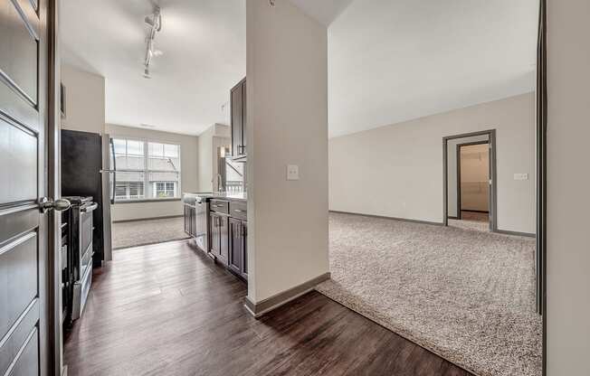 an open kitchen and living room with stainless steel appliances and wood flooring