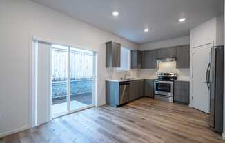 a kitchen with wood flooring and stainless steel appliances