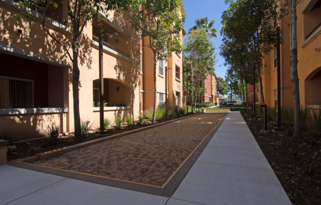 A long concrete walkway leads between two rows of buildings.