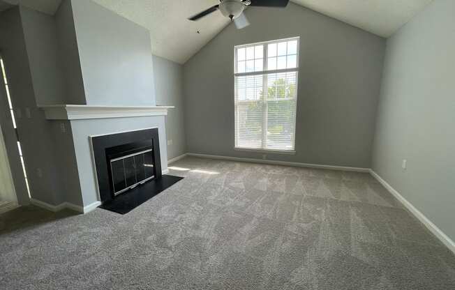 Living room with a fireplace and a ceiling fan at The Chase, Burlington, 27215