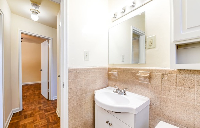 bathroom with vanity, toilet, tub and large mirror at richman apartments in washington dc