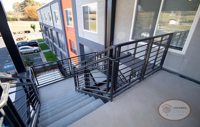 An outdoor staircase leading to the front door of apartment homes on the second story.