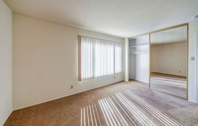 a bedroom with a large mirror and a carpeted floor at Terrace View Apartments, Daly City, CA