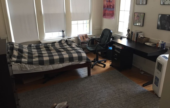 a bedroom with a bed and a desk and a chair