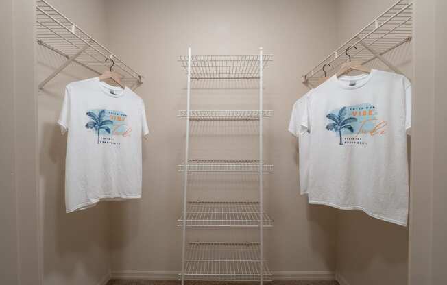 two white shirts hanging on a rack in a closet