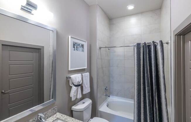 A bathroom with a toilet, sink, and shower.