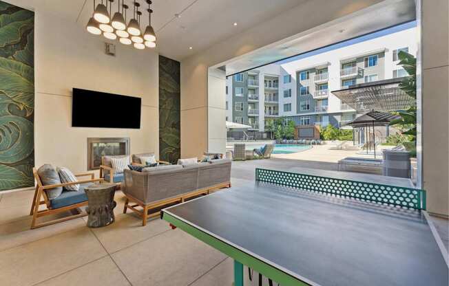 A modern living room with a pool table and a television.