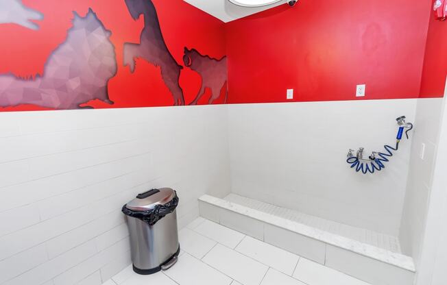 a bathroom with a red and white wall and a white tile floor