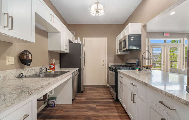 A kitchen with white cabinets in the clubhouse at Colonial Pointe at Fairview Apartments, Nebraska