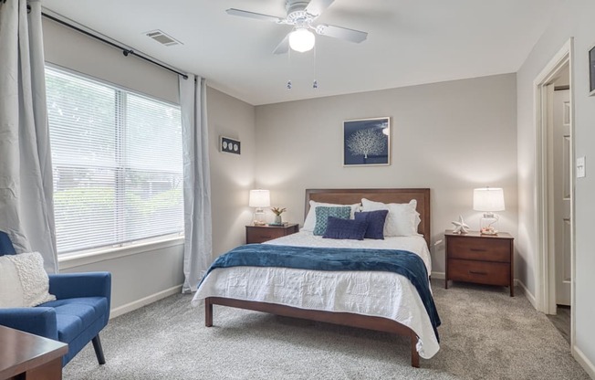 a bedroom with a bed and a ceiling fan and a window