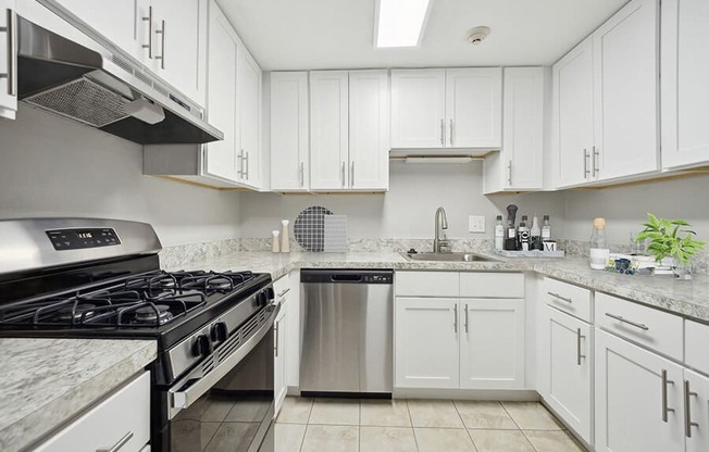 Model Kitchen with White Cabinets and Tile Flooring at Middlesex Crossing Apartments in Billerica, MA.