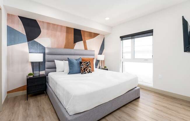 a bedroom with a large bed and a colorful wall