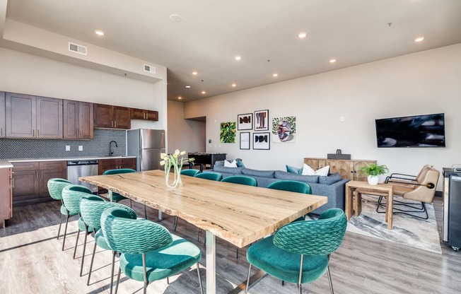 A modern open-concept living and dining area with a wooden table and green chairs.