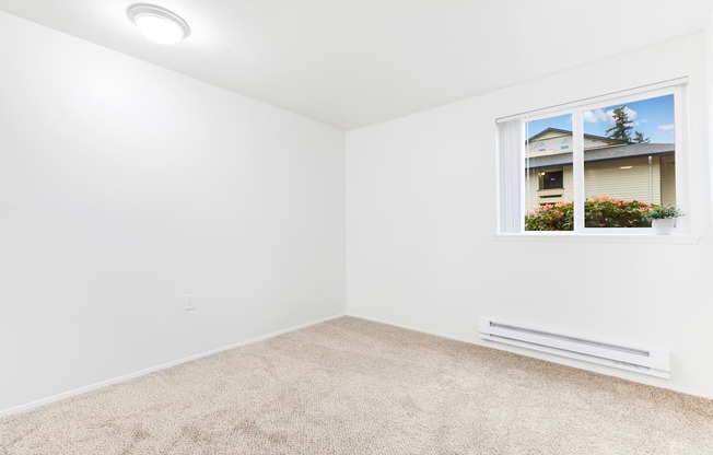 an empty room with carpet and a window