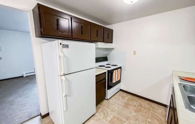 a kitchen with a refrigerator and a stove and cabinets